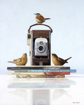 Wren in Art, by Rebecca Korth, is a hyper-realistic painting of a wren perched atop a vintage camera. The camera is flanked by wren sculptures. All of this is sitting on top of a stack of Birds in Art exhibition catalogs.