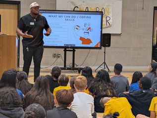 Man presents 'WHAT WE CAN DO / COPING SKILLS' to children audience.