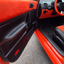 Car door panel professionally reupholstered in leather and Alcantara in Miami, with a clean, high-end automotive finish.
