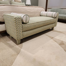 Bedroom bed-end ottoman professionally reupholstered in patterned fabric, adding texture and visual interest to the room.