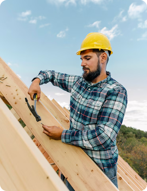 Construction worker hammering nail into wood beam