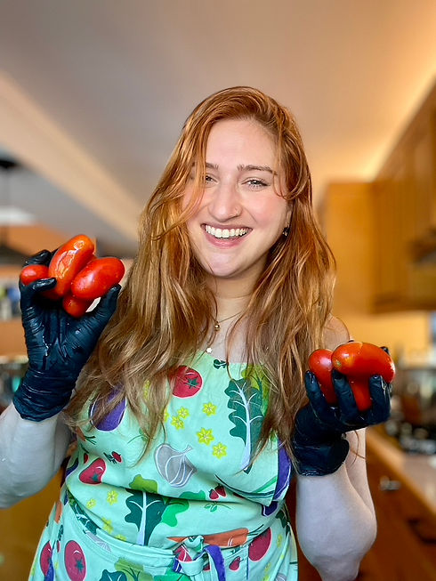 Max Seider wearing an apron holding fresh tomatoes in a kitchen