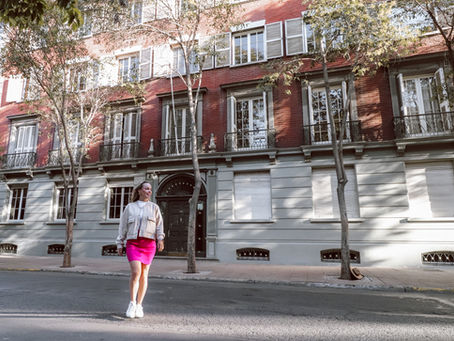 Mulher sorrindo em meio às ruas coloridas e artísticas de Lastarria durante ensaio fotográfico em Santiago.