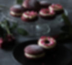 red velvet whoopie pie with cream cheese frosting and heart sprinkles on glass plate with red roses