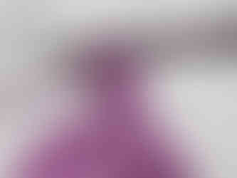 A silver crochet hook loops purple yarn into a pattern against a white background.