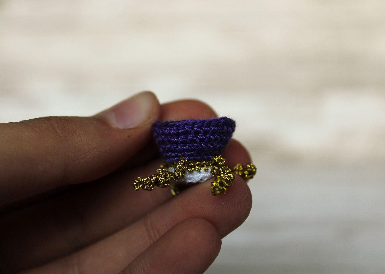 A white, purple and gold crown with a white background