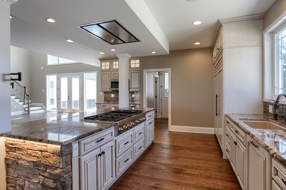 custom kitchen with stone island, granite countertops, hand made cabinets, and under lighting.