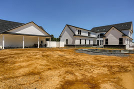 rear elevation of custom modern farmhouse with in-ground pool