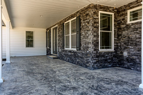 covered front porch with stamped concrete and stone work