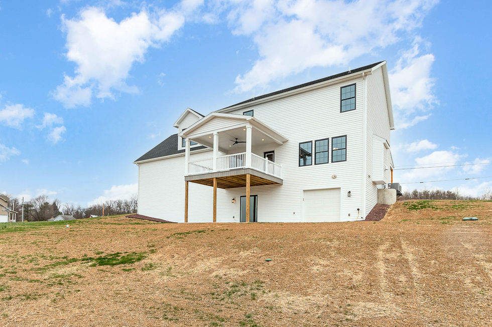 rear elevation of craftsman two story with covered deck and lower level garage