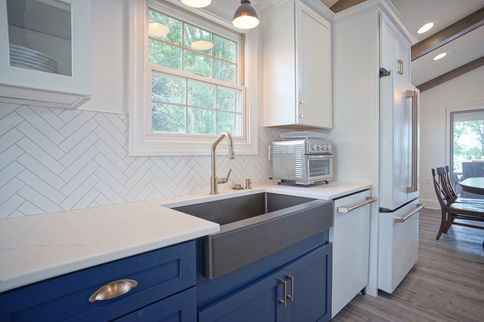Custom Kitchen with Farm Sink, Herring Bone Backsplash, an Quartz Counter Tops