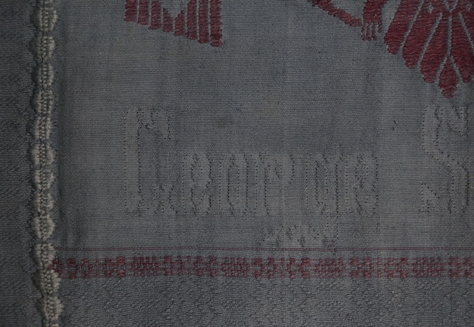 A close-up shot showing the woven surname “Sequerra” on the middle panel