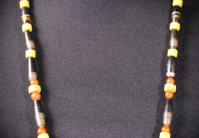 Multiple agate beads called adiongan, arranged in an alternating manner with yellow and orange beads