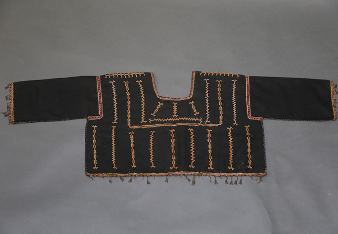 A hero shot featuring an embroidered Bugkalot blouse in black, embellished with colorful embroidery and brass coils with shell pendants