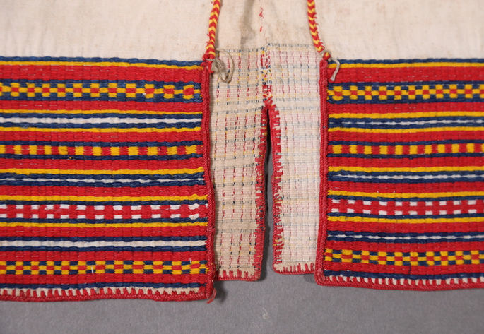 A closer look on the bottom edges of the garment, showing one slit in between at the back. The shot also highlights the multiple variations of checkered designs in supplementary weft