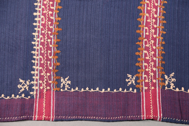 A detail shot on the purple side edges of the skirt, lined and decorated by various embroidery designs