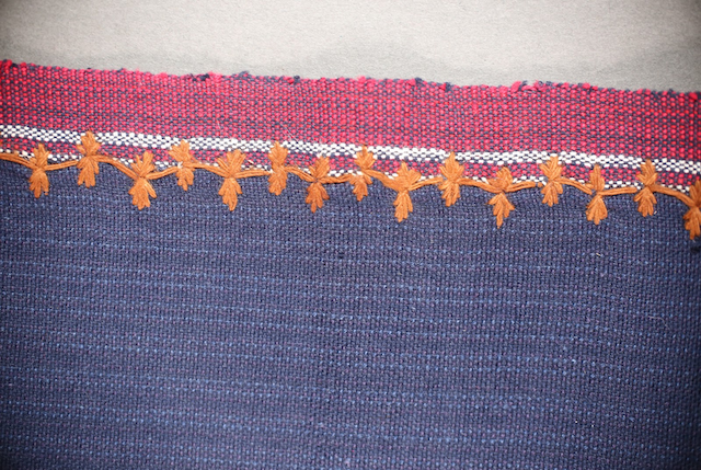 Red borders embroidered with orange mountains and fingernails embroidery design