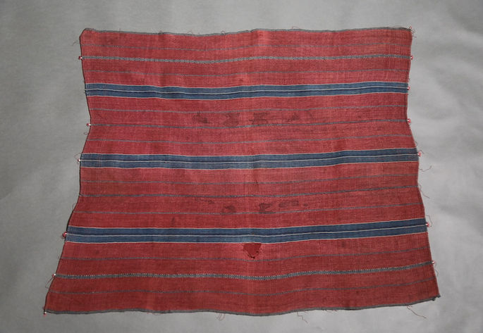 A hero shot of a two-paneled red wrap-around skirt featuring horizontal stripe designs and diamond patterns