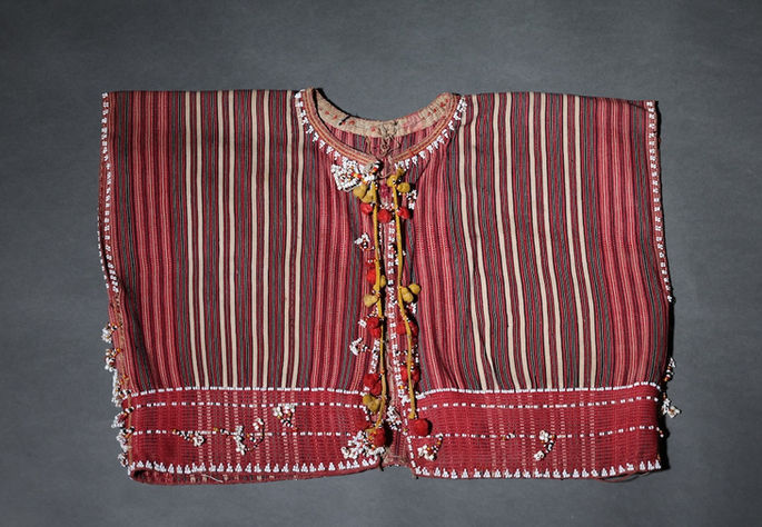 A hero shot of a Ga’dang male upper garment with vertical stripe designs and a front tie closure