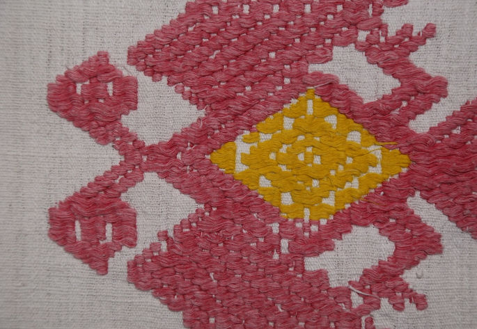 A close-up of one of the double-headed eagle figures, emphasizing the individual threads that compose the intricate inlaid pattern