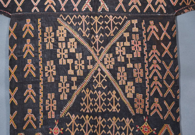 A large X motif with various abstract patterns is embroidered on the back of the bodice