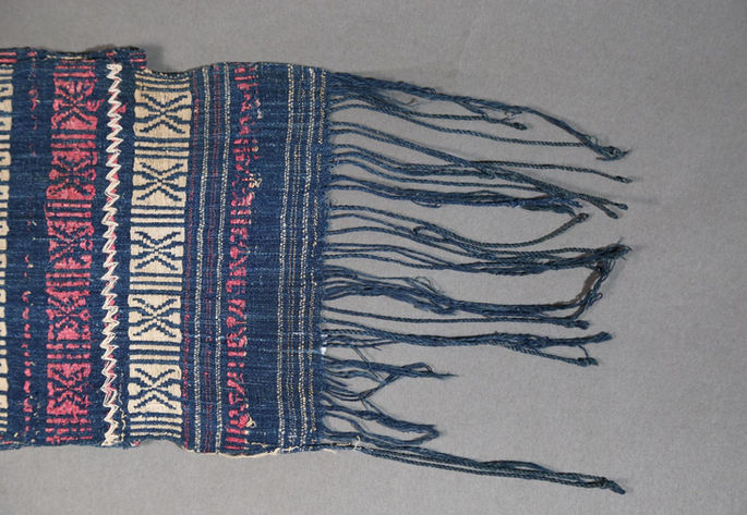 A closer look on the textile’s bottom edge showing beige embroideries on its body.
