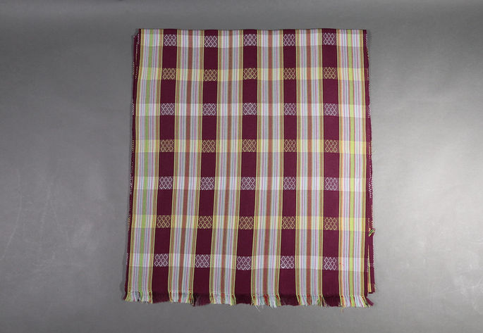 A hero shot of a violet-colored striped yardage with multi-colored striped designs and crisscross-like motifs