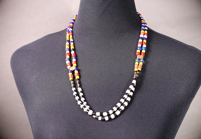 A display shot of a double-layered, chest-length Itneg bead necklace featuring multicolored glass trade beads and agate