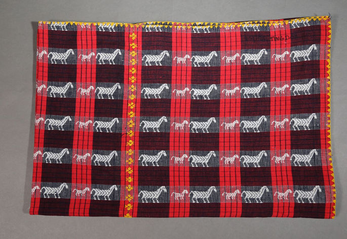 A hero shot of a woven blanket from Abra with small and bigger horse motifs.