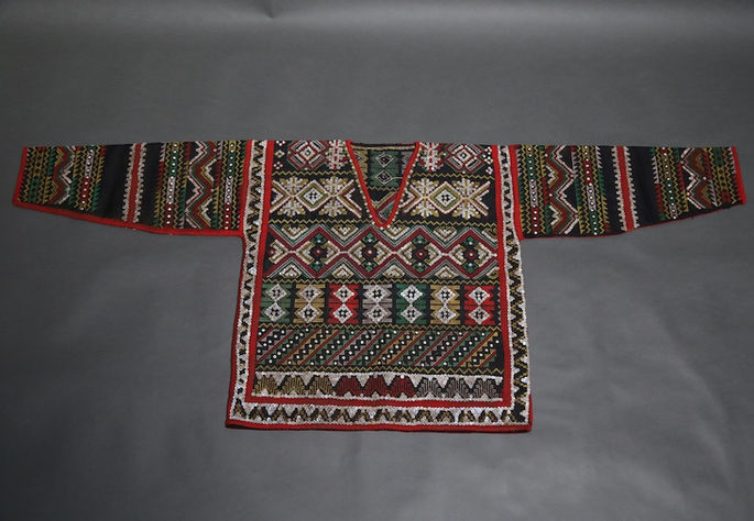 A hero shot of a female upper garment with a black cotton base, featuring embroidery, shell sequins, and appliqué