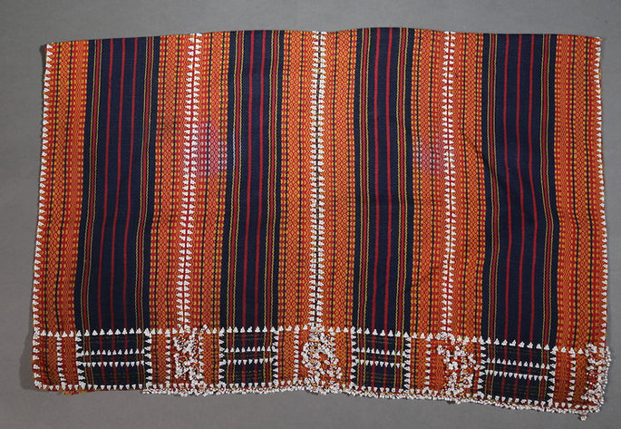 A hero shot featuring a beaded skirt with indigo, red, and yellow stripes