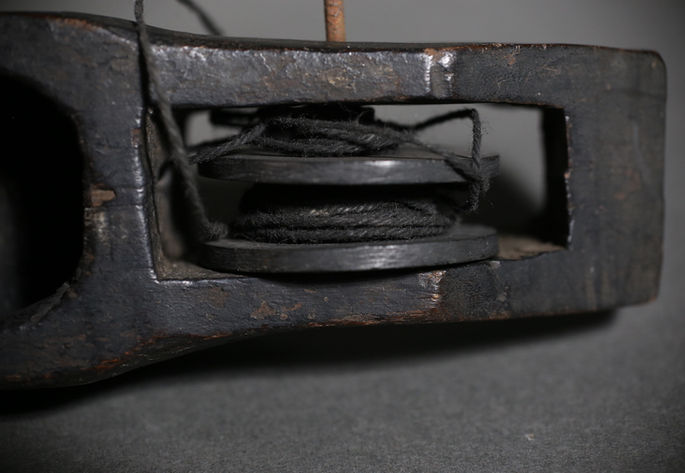A twisted black thread is spooled arounf the wheel