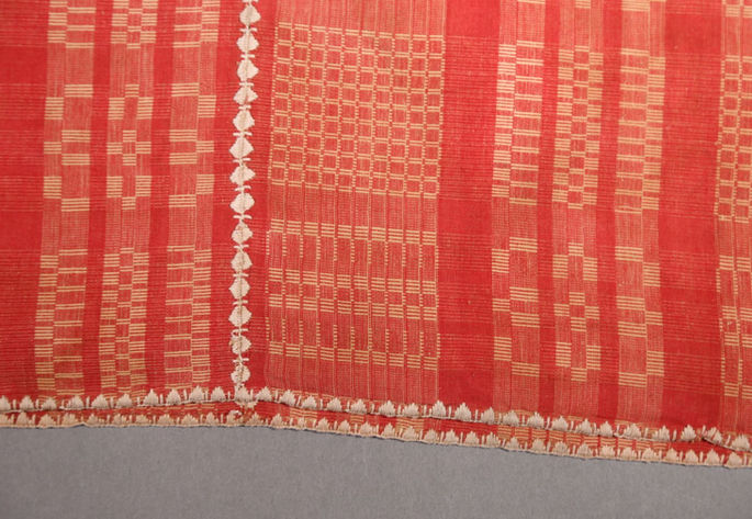 A detailed shot showing the white stylized embroidery joining the panels and securing the borders of the textile.