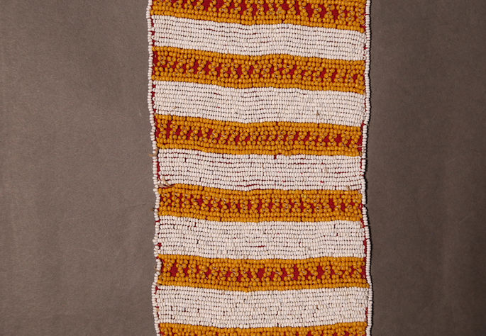 A detail shot of the white and yellow beads embroidered on the textile