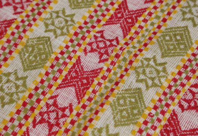 A detailed shot focusing on the X-shaped mortar-like motifs in red colors.