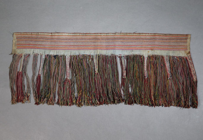 A hero shot of an Isnag backskirt featuring colorful tassels and fine embroidery.