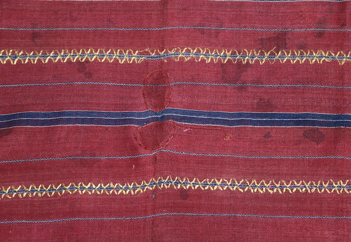 A section of the skirt showing gold metallic embroidery running parallel to the indigo stripes