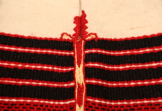 A close-up shot detailing the black and red stripes design and the seam embroidery on the body of the hip bag.