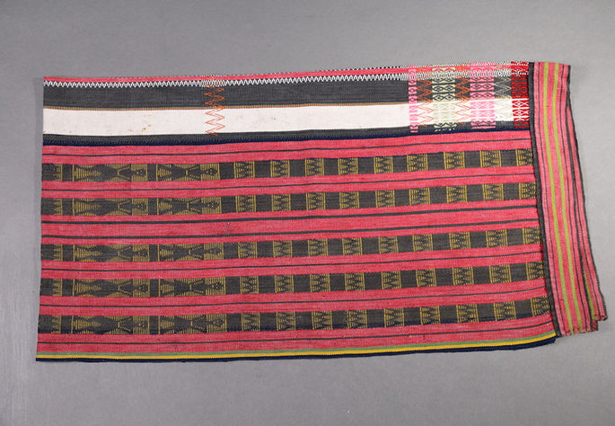 A hero shot of a three-paneled wrap-around skirt featuring red, black, and white stripes and multiple brocade patterns at the central panel