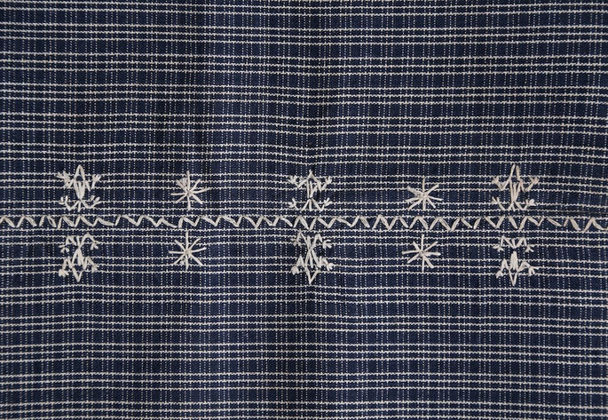 A close-up shot featuring two sets of lizard-like and star-like (asterisk) motifs arranged in a pattern, flanking the zigzag pattern in the middle