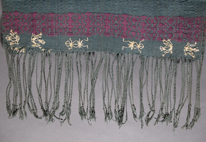 Details of the embroidered zigzag and finger-like shapes at the lower edges