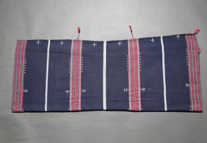 A hero shot of a kinamayan wrap-around skirt with an indigo background, featuring red and white bands and multiple embroideries