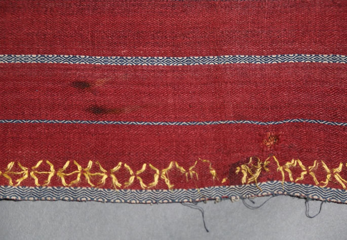 The bottom section of the skirt, showing visible fabric runs, dirt marks, and a hole