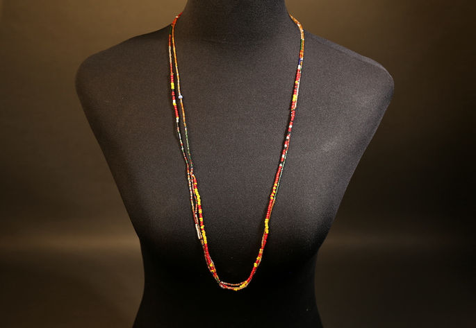 A display shot of a double-layered necklace composed of small, multicolored glass beads