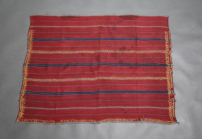 A hero shot of a three-paneled wrap-around skirt with horizontal stripe designs and diamond patterns, accented with embroidery in metallic threads
