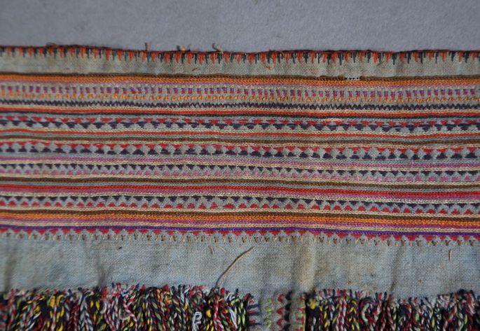 A close-up shot featuring the colorful and fine embroidery on the waistband.
