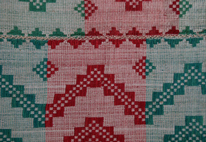 The river motifs in the textile appear to be in zigzag patterns with small diamond motifs.