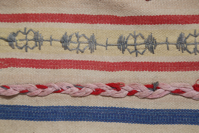 A detailed shot featuring the plain-woven stripes, braided yarns, and continuous embroidery
