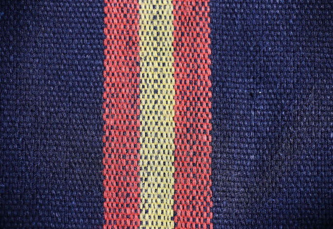 A detail shot of one of the striped bands woven in orange and yellow threads