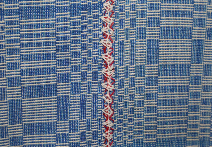 The blanket’s panels were joined by red and white simple stitches.